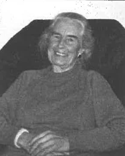 Femme âgée souriant, portrait en noir et blanc.